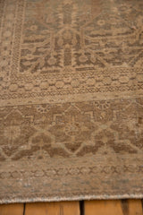 Detail of a distressed antique Tabriz carpet, showing faded sandalwood and beige lattice panels with floral guls.