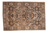 A distressed vintage Khoy carpet with a central medallion and sprawling cloudband motifs in tones of sand, charcoal, and brown.
