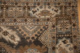 Corner detail of a vintage Khoy carpet's geometric cartouche border in brown, sand, and silver.