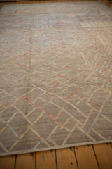 Low angle view of a Pakistani carpet's textured pile, showing mostly even wear and primitive line work.