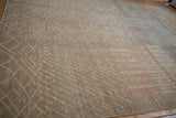 Textured hand-knotted pile of a silver carpet showing mostly even wear across the knot heads.