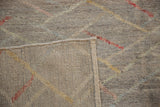 A folded corner revealing the hand-knotted construction and side selvage of the Pakistani rug.