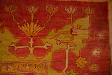 Close-up of the antique Oushak's short pile, with floral motifs in saffron and lime green.