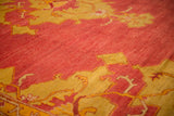 Mostly even short pile on an antique Turkish Oushak in dusty cochineal red and saffron.