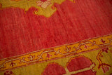 Hand-knotted short pile texture on an antique Oushak in cochineal red and saffron yellow.