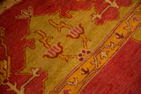 Corner detail of an antique Oushak's mostly even short pile in cochineal red and saffron yellow.