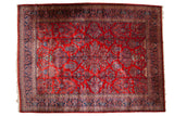 Vintage Persian Kazvin carpet with allover floral potted plants on a cherry red field and a wide navy blue border.