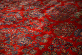 Rich texture of a vintage Kazvin carpet's cherry red pile with sapphire blue floral motifs.
