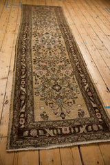 A perspective view down the length of the vintage Bibikabad runner showing its distressed floral pattern.