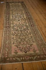 Vintage Bibikabad runner from an angle, showcasing its full length, floral pattern, and distressed, time-softened patina.
