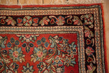 Corner detail of a vintage Sarouk runner with intricate floral borders and a plush cherry red pile.
