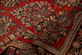 A folded view of a vintage Sarouk runner showing the dense, even pile and cherry red floral pattern.
