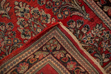 Corner of a vintage Persian Sarouk rug, showing the hand-knotted back and dense red floral pile.