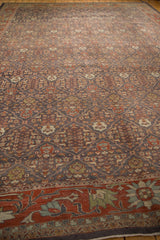 Mahal carpet's distressed charcoal lattice field, henna palmettes, and deep red lotus border.