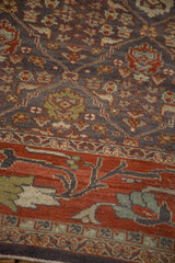 Distressed Mahal rug showing cherry red lotus vine border and charcoal blue palmette field.
