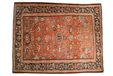 Antique Sultanabad carpet with a scalloped medallion and elaborate paisley blossoms on a madder red field.