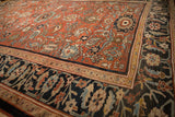 Antique Sultanabad carpet corner with a charcoal Herati border and madder red floral field.
