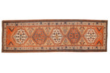 Antique Serab runner with interconnected geometric medallions in terracotta and blue over a warm camel field.