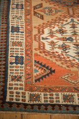 Close-up of the antique Serab's reciprocating pawn and meandering vine borders in terracotta and blue.