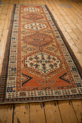 Angled view of an antique Serab runner highlighting the interconnected medallions and reciprocating pawn border.
