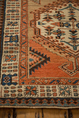 Close-up on the reciprocating pawn motif and hand-knotted texture of an antique Serab rug.