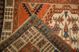 Folded corner of an antique Serab rug showing the pawn border and its hand-knotted wool foundation.