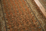 Serrated plant motifs and colorful barber pole border on a distressed vintage Malayer runner rug.