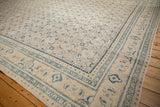 Angled view of a distressed Persian Mahal showing the ivory Herati field and blue Turtle border.