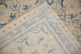Close-up of a folded corner on a distressed Mahal rug, showing the hand-knotted weave and worn pile.