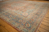 Distressed vintage Meshed carpet corner, faded blue spandrel, intricate scrolling vines, and cherry blossoms.