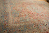Distressed vintage Meshed carpet with cherry red field, scrolling vines, and slate blue border.