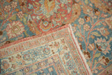 Distressed vintage Meshed rug fold, highlighting worn pile, slate blue field, and red patterned border.