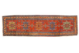 Antique Heriz runner with geometric medallions in sapphire blue and jade green on a brick red field.
