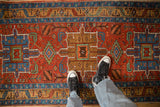 A downward view showing the low-pile texture and geometric medallions of an antique Heriz runner.