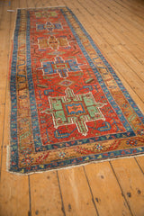 Angled view of an antique Heriz runner, showcasing the linear column of geometric medallions and intricate borders.