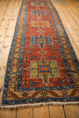 A perspective view of the antique Heriz runner showing the full column of geometric medallions.