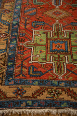 A view of the antique Heriz runner's geometric border and low-cut wool pile in sapphire blue, jade green, and brick red.