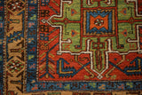 Geometric corner detail of an antique Heriz runner with a brick red field and sapphire blue border.