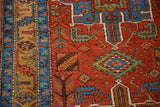A detailed view of the sapphire blue serpent border and geometric plant designs in brick red.