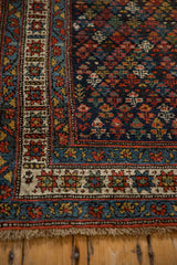 Corner view of a vintage Kurdish runner highlighting its short pile and intricate geometric borders.