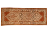 Vintage Serab runner with a column of interconnected medallions in terracotta, ivory, and olive green.