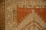 Geometric pawn design border and stepped medallion on a vintage Serab rug in terracotta and olive tones.