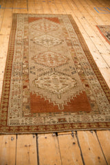 Angled full view of a distressed Serab runner highlighting its geometric medallions and terracotta ends.