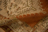 Low-pile texture of a distressed Persian runner, folded to show its terracotta medallion.