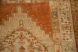 Detail of the worn pile, showing geometric stepped designs in terracotta, ivory, and sage green.