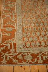 Detail of the low, even wear on an antique Hamadan rug's terracotta and silver geometric design.