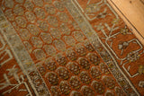 Geometric relief of the scrolled vine border on an antique distressed Hamadan rug runner.