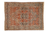 Vintage Persian Bijar rug with concentric hexagonal medallions in rust red, dark blue, and dusty teal.