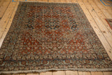 Angled view of a vintage Bijar rug highlighting its Herati design and hexagonal medallions.