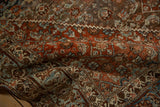 Softly folded corner showing the pomegranate and turtle border of the vintage Bijar rug.